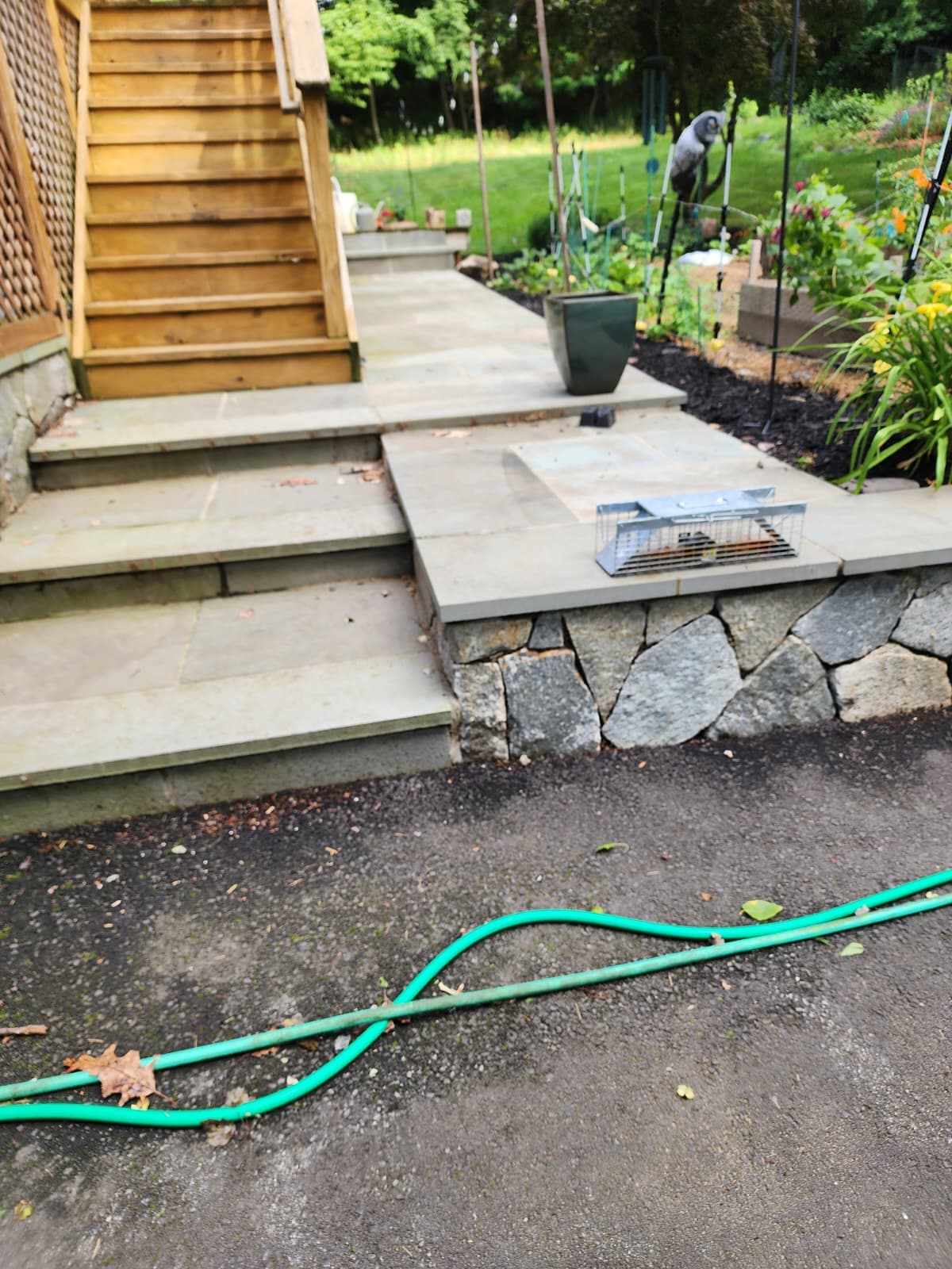 Bluestone patio with fieldstone wall — Connecticut Bluestone patio with a fieldstone retaining wall and stone steps beside a garden