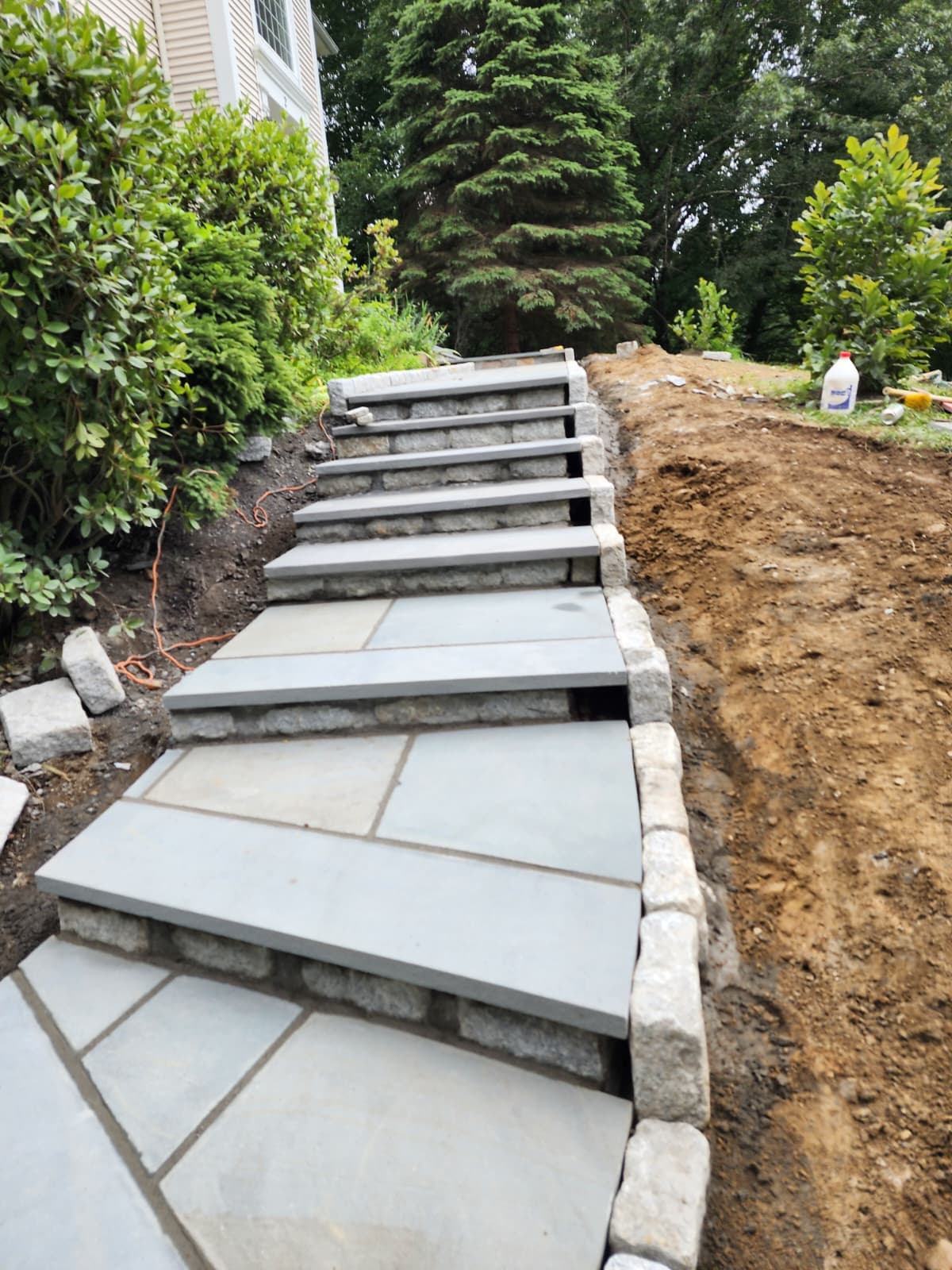 Bluestone steps with granite block risers climbing a landscaped Connecticut slope
