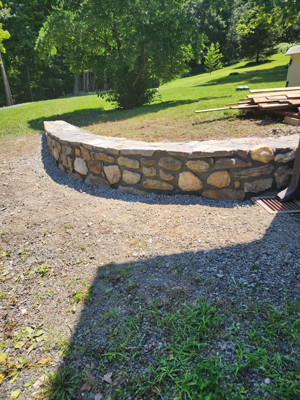 Natural stone seat wall — Connecticut Curved natural stone seat wall set into a backyard landscape