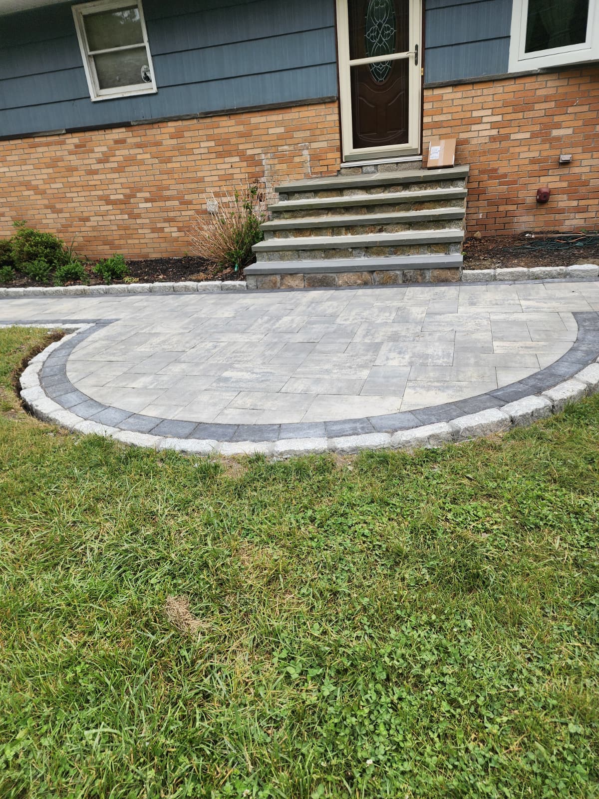 Curved paver patio — Connecticut Curved paver patio with a contrasting border at a home entrance